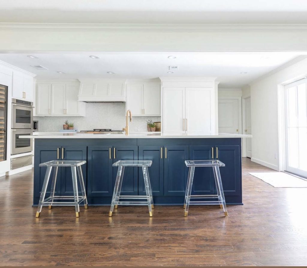 Bold blue kitchen island in white kitchen with wood stained floor